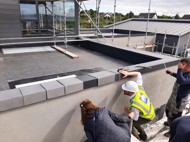 Gemma Inspecting Zinc Installation on Building